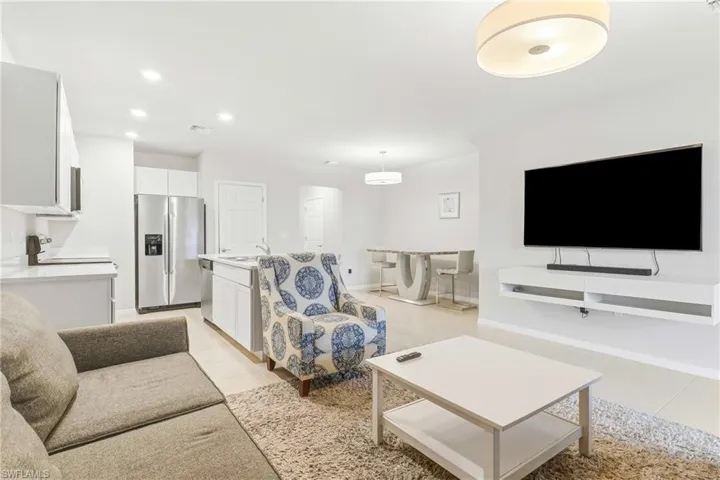 Living room featuring light tile patterned flooring and recessed lighting