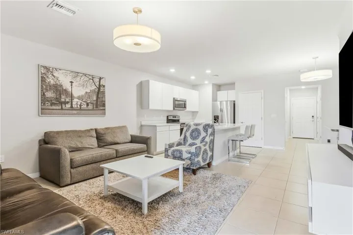 Living area with light tile patterned flooring and recessed lighting