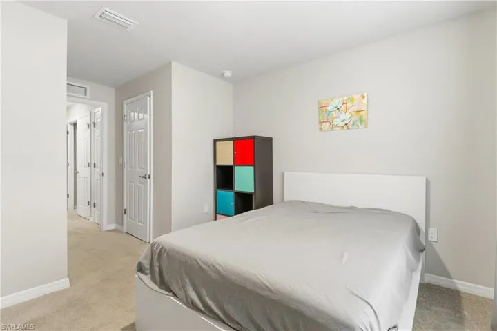 Bedroom featuring light colored carpet and a closet