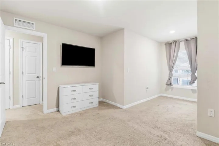 Unfurnished bedroom featuring light carpet and baseboards