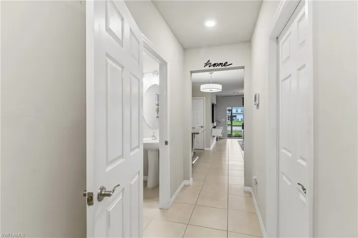 Hall featuring light tile patterned flooring and baseboards