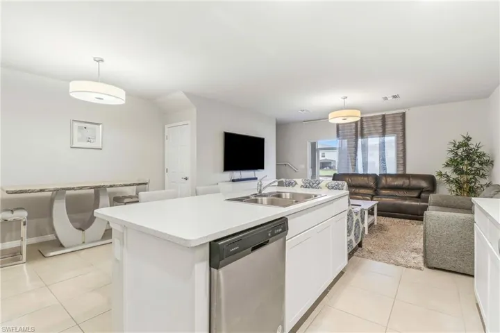 Kitchen featuring white cabinets, open floor plan, dishwasher, and pendant lighting