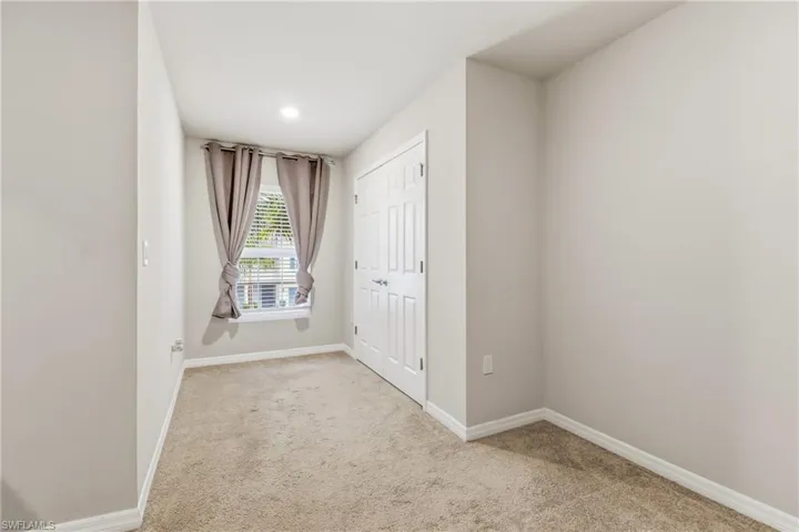 Unfurnished bedroom featuring light carpet and a closet