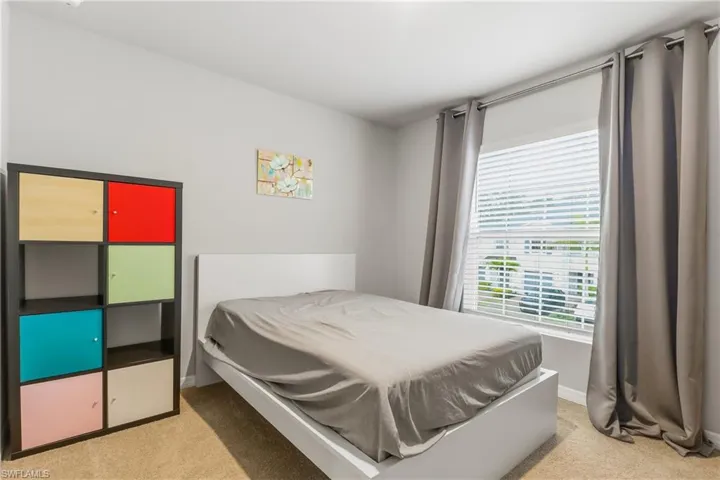 Bedroom with light carpet and baseboards