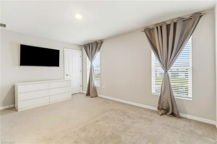 Unfurnished bedroom with carpet flooring and baseboards