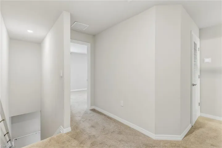 Hall featuring carpet flooring and baseboards
