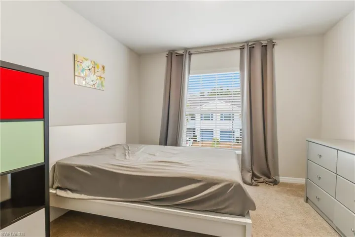 Bedroom with light carpet and baseboards