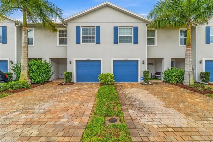 View of front of property featuring stucco siding, driveway, and a garage
