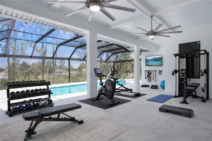 Virtually Staged  Exercise room featuring a sunroom and beamed ceiling