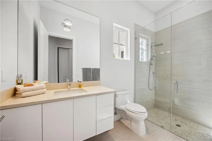 Bathroom with vanity, a shower stall, and light tile patterned flooring