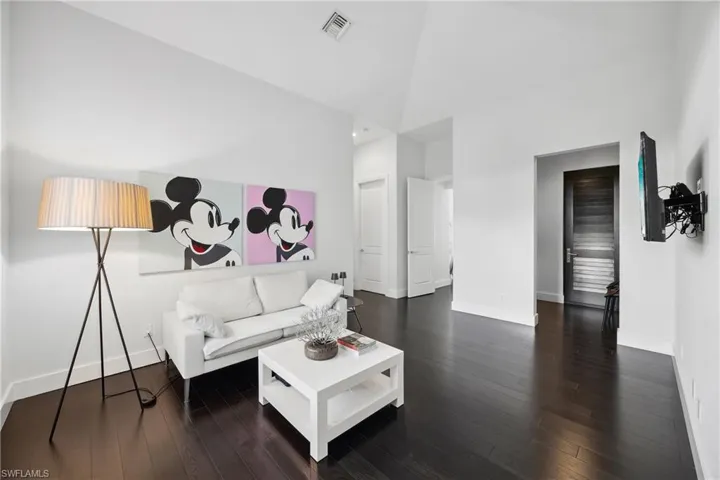 Living area featuring high vaulted ceiling and dark wood-type flooring