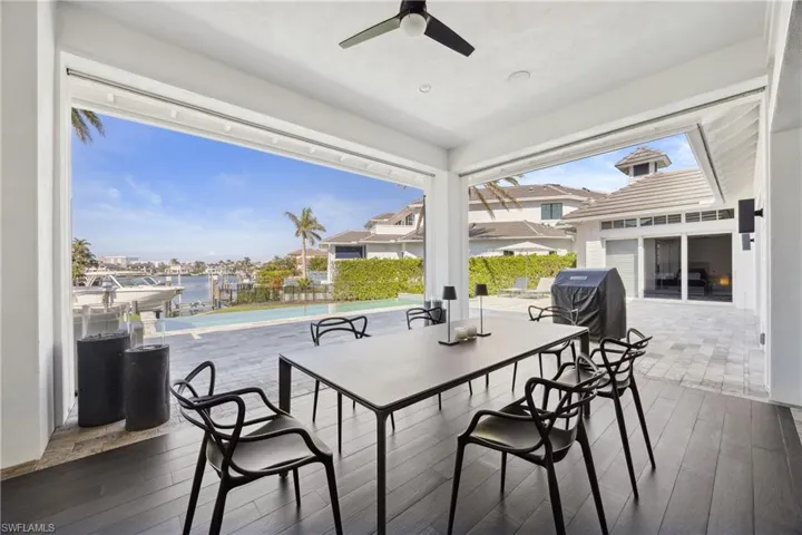Deck with a patio area, ceiling fan, grilling area, and a water view