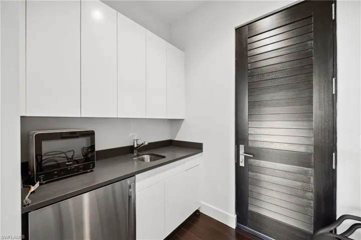 Bar with dishwasher, dark wood finished floors, white cabinets, and modern cabinets
