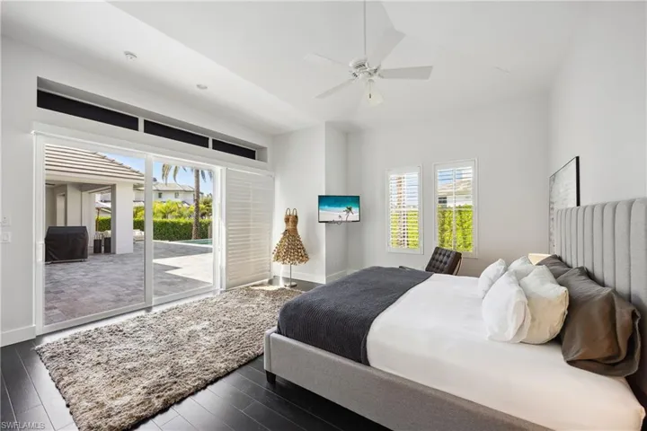 Bedroom featuring access to outside, dark wood-type flooring, and ceiling fan