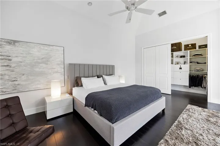 Bedroom featuring a closet, dark wood-style flooring, a high ceiling, and ceiling fan