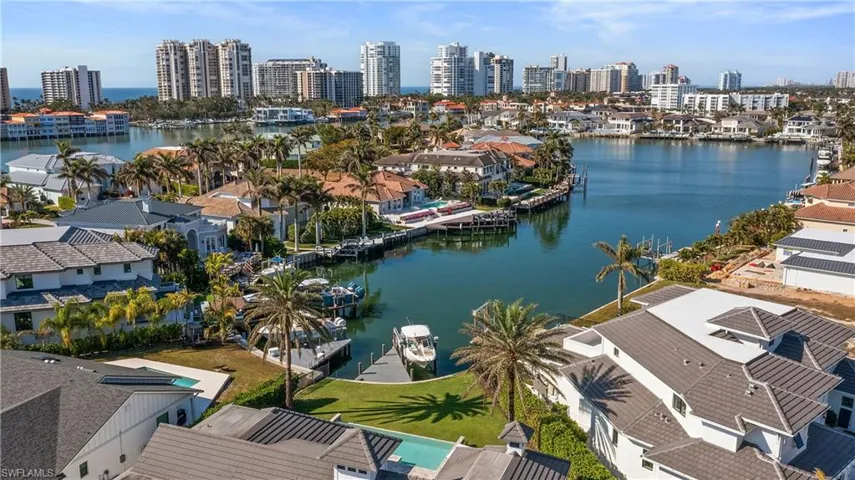 Aerial view of residential area featuring a nearby body of water and skyline