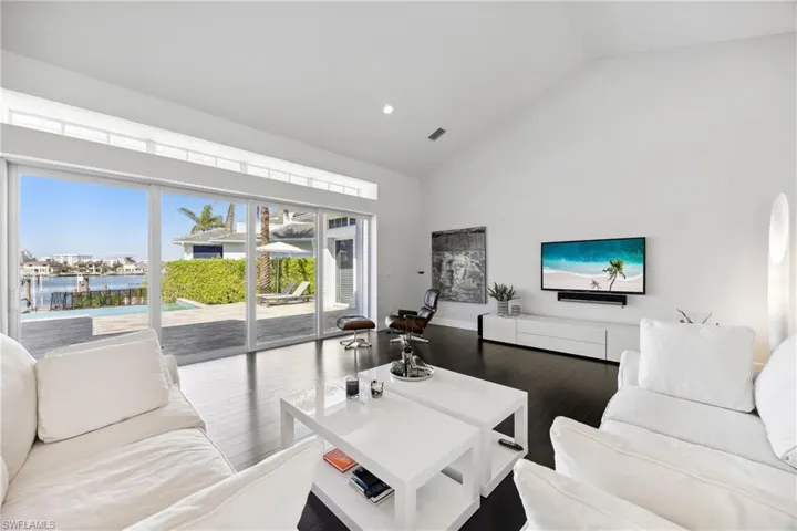 Living area featuring high vaulted ceiling, wood finished floors, and recessed lighting