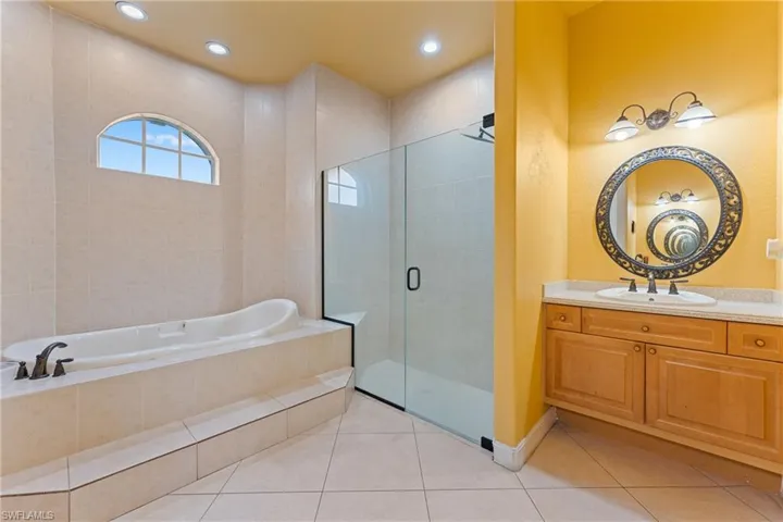 Bathroom featuring vanity, separate shower and tub, and tile patterned flooring