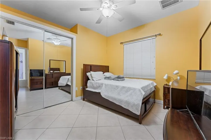 Bedroom with ceiling fan and light tile patterned flooring