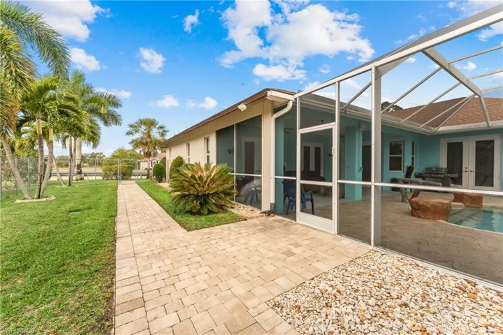 Back of house featuring a lanai, a patio area, french doors, and a yard