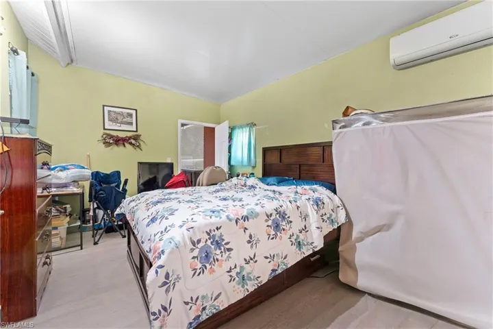 Bedroom with light wood-type flooring and a wall mounted air conditioner