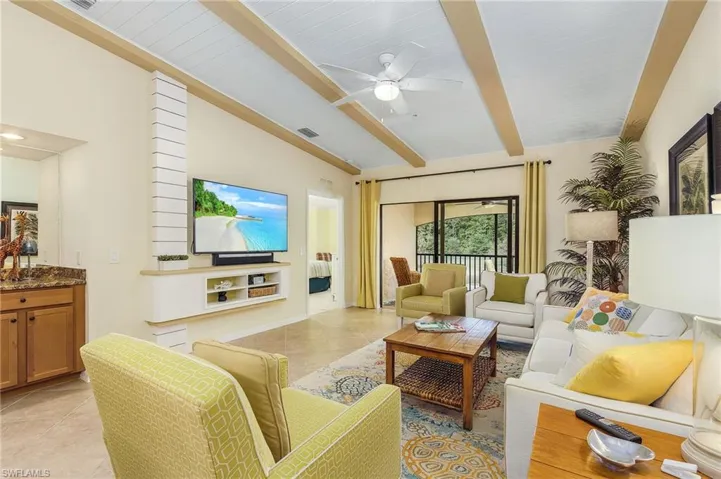 Living area featuring light tile patterned floors and a ceiling fan