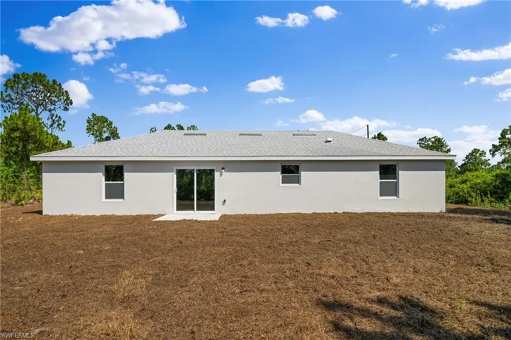 Rear view of property with a yard