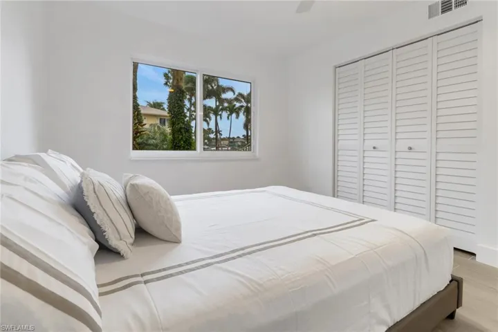 Bedroom featuring light wood-type flooring, ceiling fan, visible vents, and a closet
