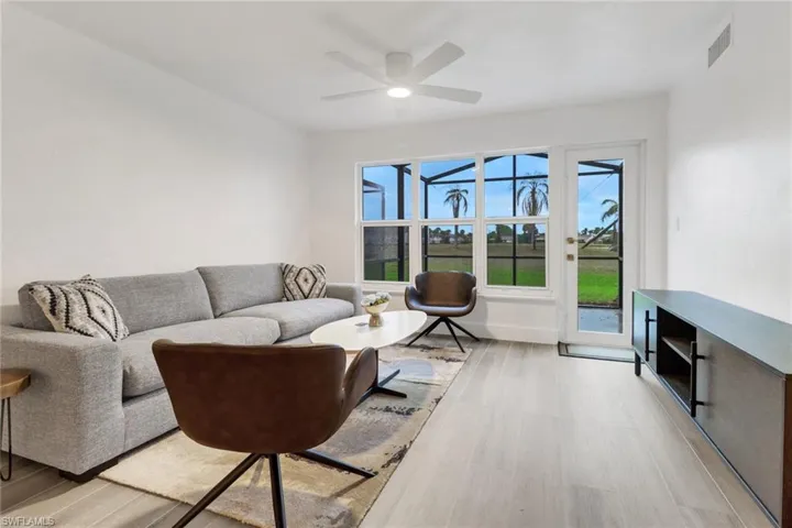 Living room with ceiling fan, baseboards, visible vents, and light wood-style floors