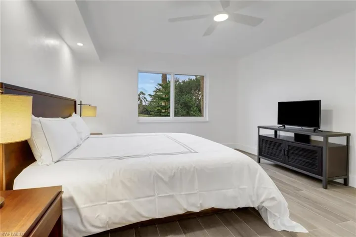 Bedroom featuring recessed lighting, ceiling fan, baseboards, and wood finish floors