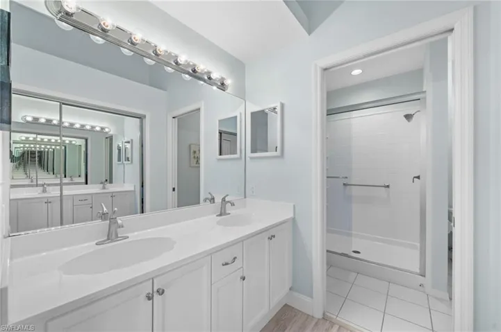 Bathroom featuring vanity and a shower with door