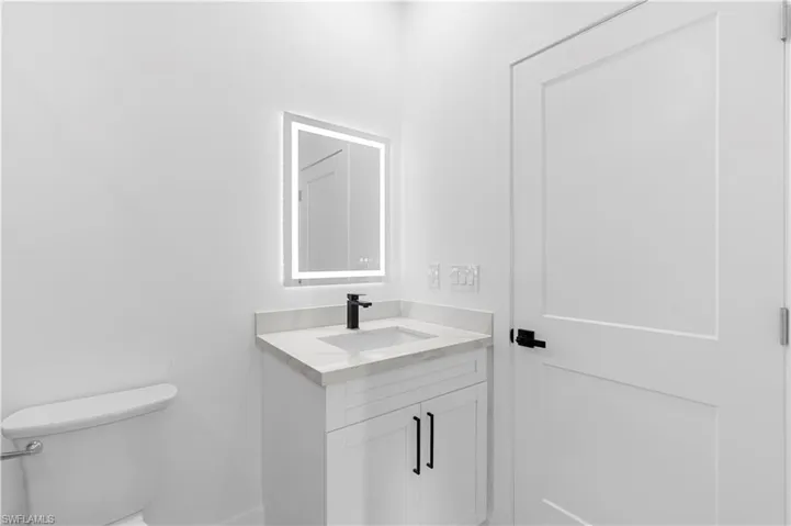 Half bathroom featuring vanity and toilet