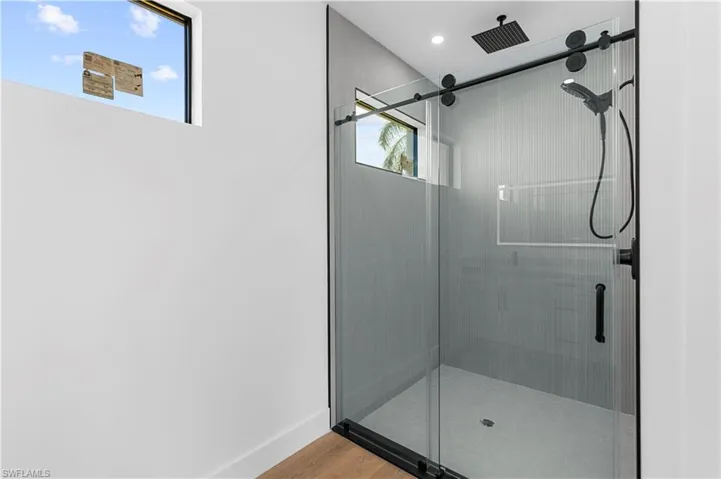 Bathroom with a shower stall and light wood-style floors