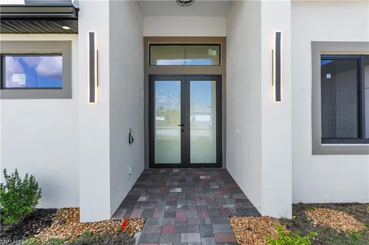 Entrance to property featuring french doors and stucco siding