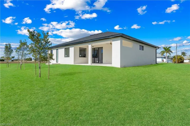 Back of property featuring a yard, a patio, stucco siding, and ceiling fan