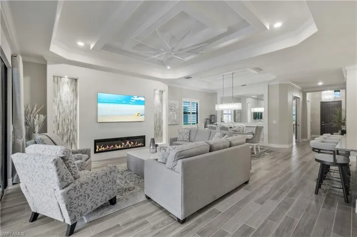 Great Room with Custom Fireplace, Coffered Ceiling and Dining room view
