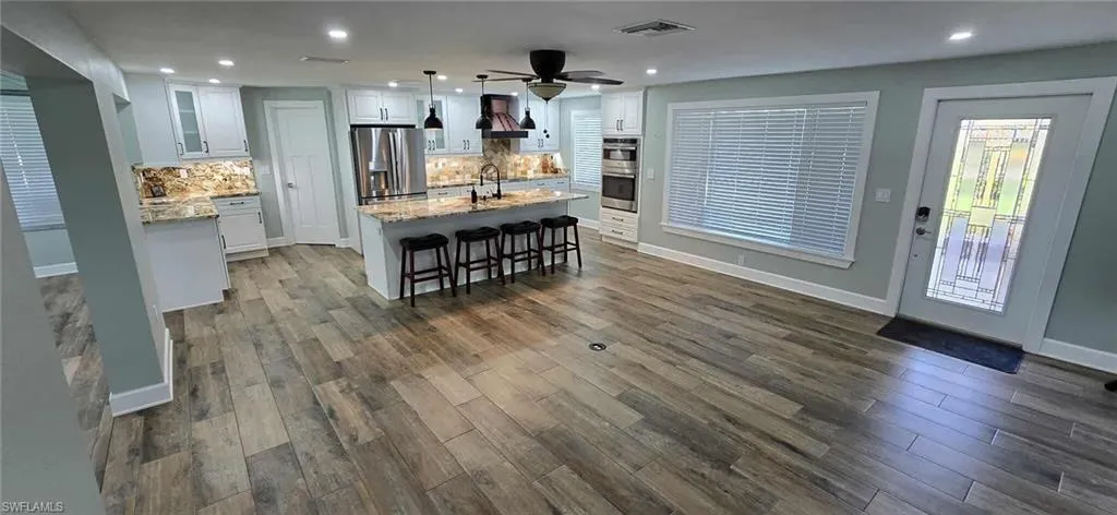 Kitchen with white cabinets, a sink, visible vents, appliances with stainless steel finishes, and premium range hood