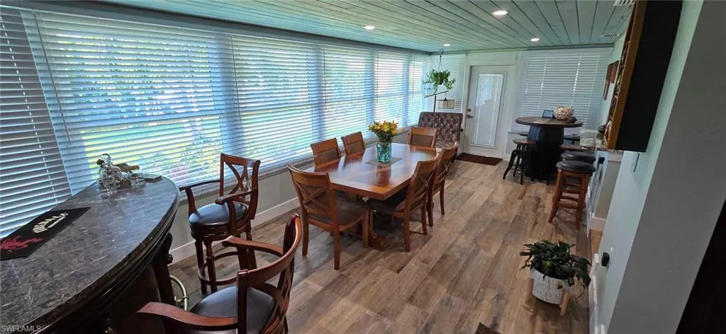 Dining space featuring baseboards, wood finished floors, wood ceiling, and recessed lighting