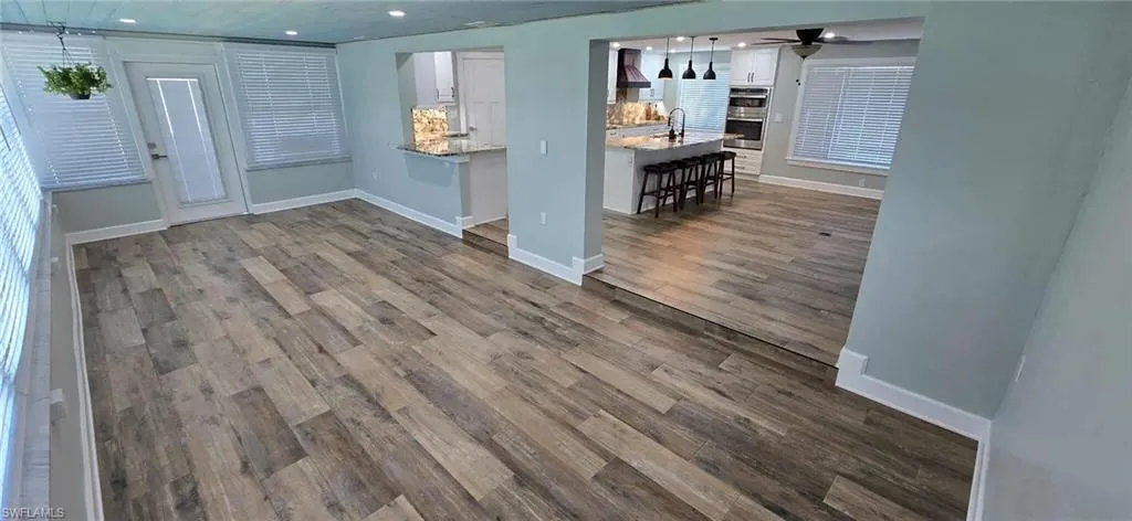 Living area with recessed lighting, dark wood-type flooring, baseboards, and ceiling fan