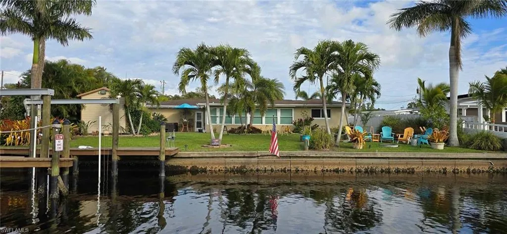 Rear view of house featuring a yard and a water view