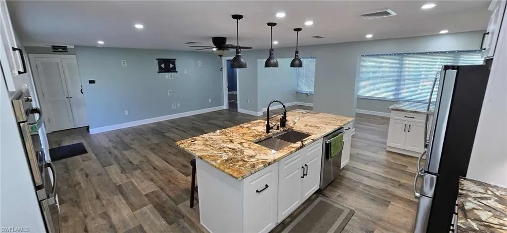 Kitchen featuring stainless steel appliances, a kitchen island with sink, a sink, visible vents, and a ceiling fan