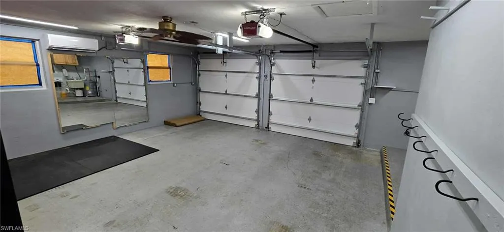 Garage with an AC wall unit and a garage door opener