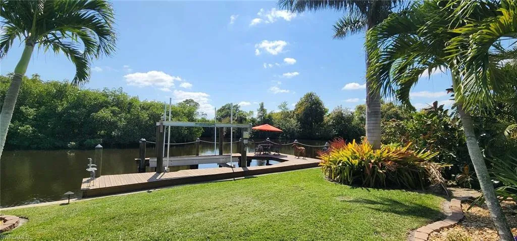 Dock area featuring a water view, a yard, and boat lift