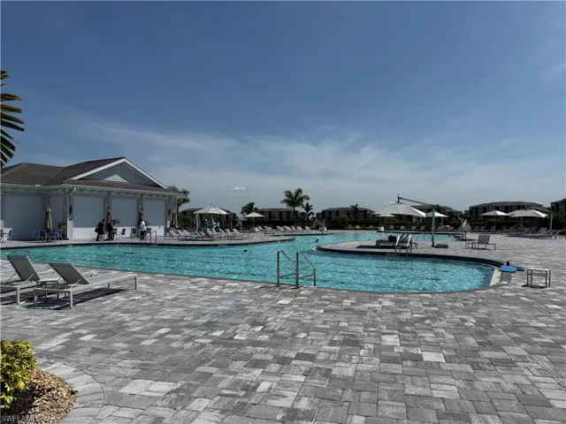 Expansive private pool deck featuring multi-toned paver flooring
