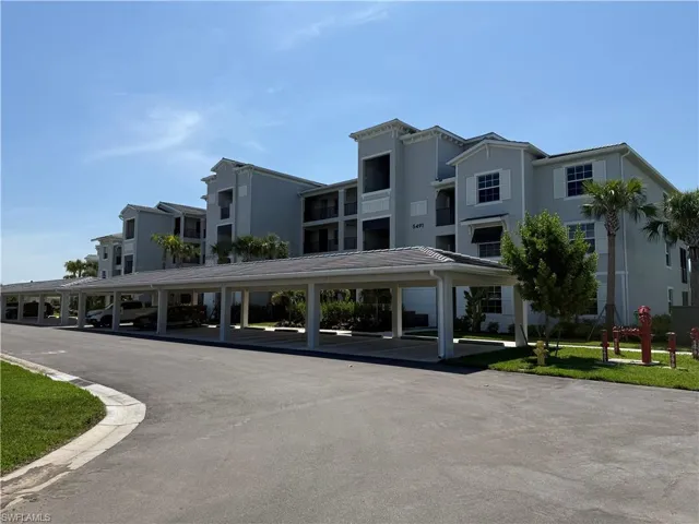 Multi-story residential structure featuring a covered parking area with multiple bays