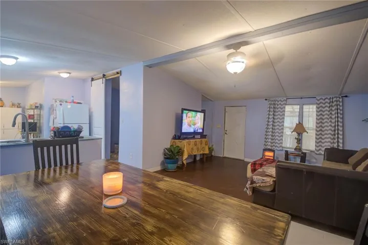 Dining area with a barn door, baseboards, and vaulted ceiling
