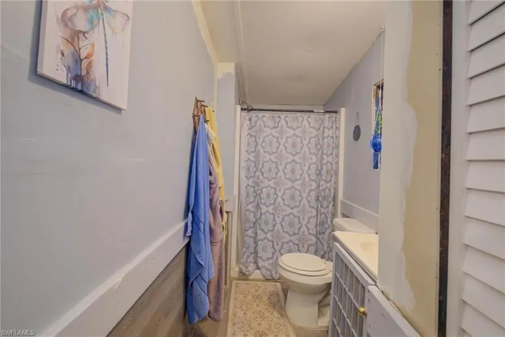 Full bath with curtained shower, vanity, and toilet