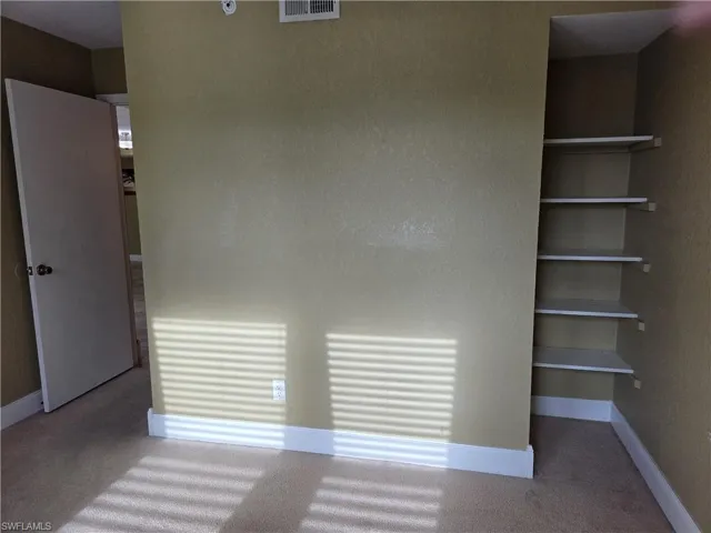 Unfurnished bedroom with light colored carpet