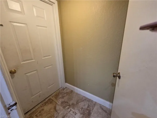 Entryway with baseboards and a textured wall