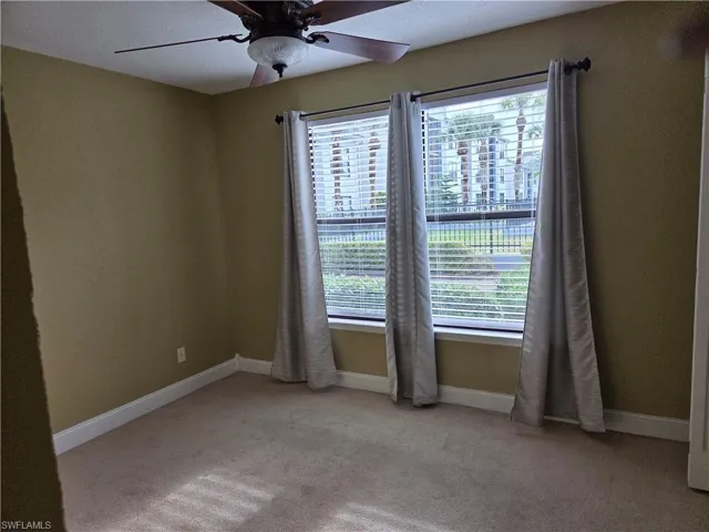 Unfurnished room featuring a ceiling fan and light carpet